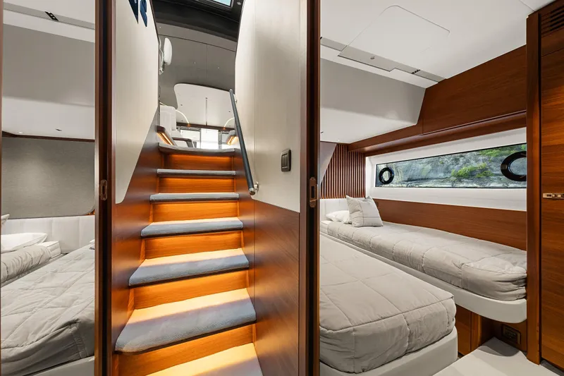 S72515 Yacht Photos Pics Luxurious interior of 2023 Princess S72 yacht with twin beds and wooden staircase.