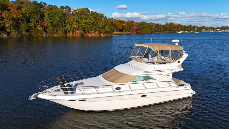 Messing About Yacht Photos Pics 2003 Sea Ray 400 Sedan Bridge yacht on a serene lake with autumn trees.
