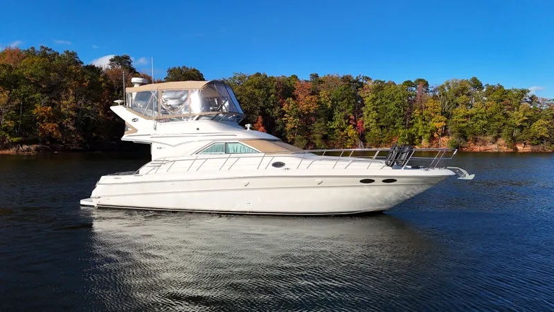 Messing About Yacht Photos Pics 2003 Sea Ray 400 Sedan Bridge yacht on a serene lake with forested background.