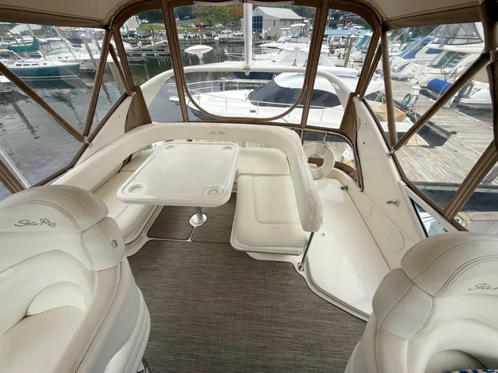 Messing About Yacht Photos Pics 2003 Sea Ray 400 Sedan Bridge interior with white seating and table, docked at marina.