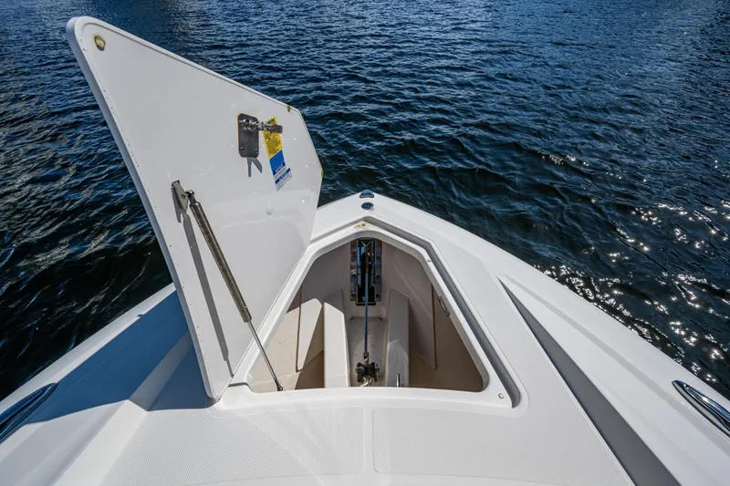 Never Say Never Yacht Photos Pics Open hatch on 2021 Tiara Yachts 34 LX, revealing storage compartment, with water in background.