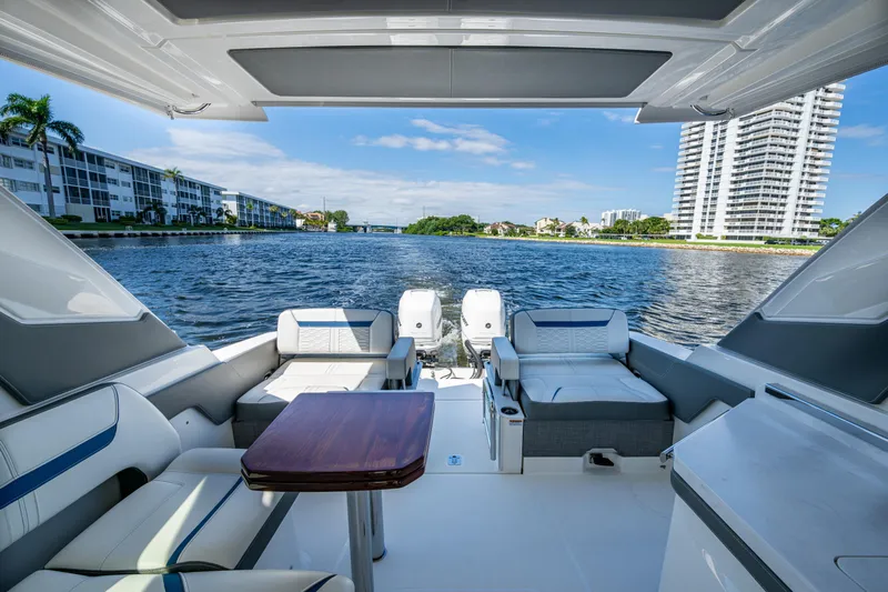 Never Say Never Yacht Photos Pics 2021 Tiara Yachts 34 LX interior with waterfront view, featuring luxurious seating and table.