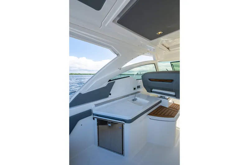 Never Say Never Yacht Photos Pics Interior view of 2021 Tiara Yachts 34 LX, featuring a sleek kitchenette and seating area.