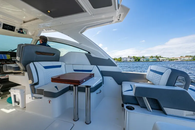 Never Say Never Yacht Photos Pics 2021 Tiara Yachts 34 LX interior with seating and table, overlooking water.