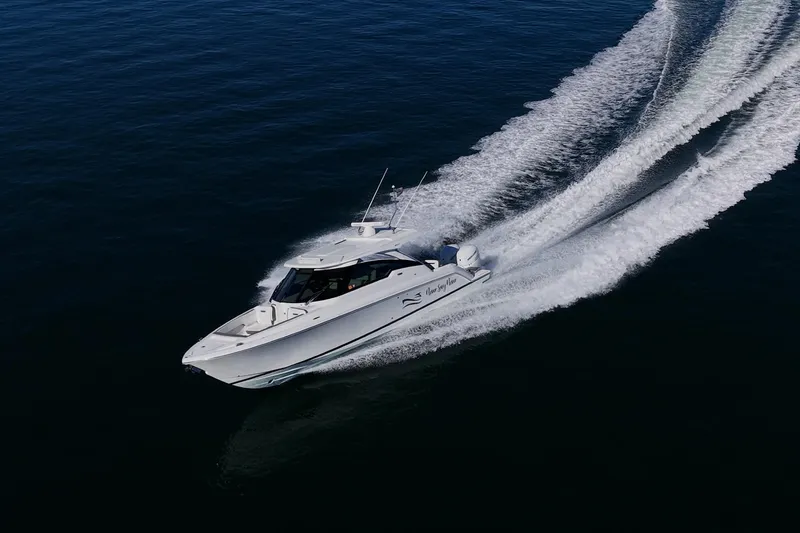 Never Say Never Yacht Photos Pics 2021 Tiara Yachts 34 LX cruising on open water, creating a dynamic wake.