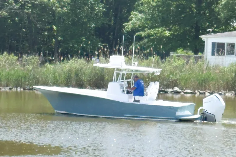  Yacht Photos Pics 2025 Weaver 270 boat cruising on a calm river near a wooded shoreline.