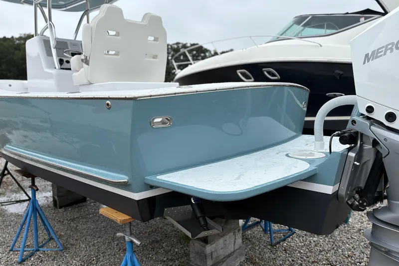  Yacht Photos Pics 2025 Weaver 270 boat with blue hull and white seating, displayed on stands.