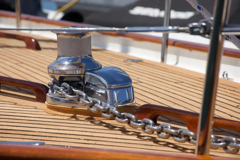 Volunteer Yacht Photos Pics Polished anchor winch on 1996 Bruckmann Yachts deck with wooden finish.