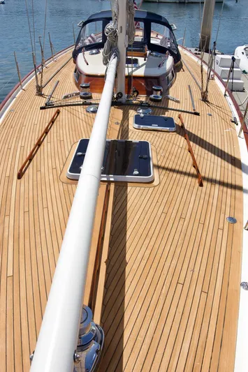 Volunteer Yacht Photos Pics 1996 Custom Bruckmann Yachts sailboat with wooden deck and mast, docked in a marina.