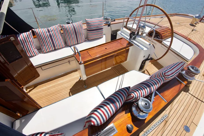 Volunteer Yacht Photos Pics Luxurious 1996 Bruckmann Yachts cockpit with striped cushions and wooden deck.