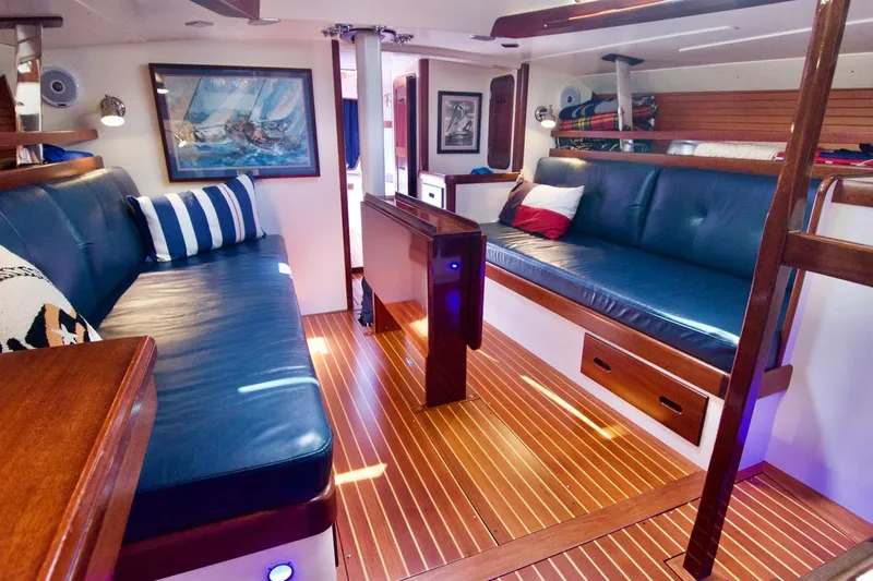 Volunteer Yacht Photos Pics Luxurious 1996 Bruckmann Yachts interior with blue leather seating and elegant wood flooring.