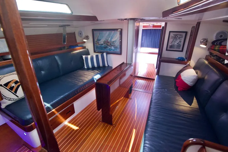 Volunteer Yacht Photos Pics Luxurious 1996 Bruckmann Yachts interior with blue leather seating and elegant wood finishes.