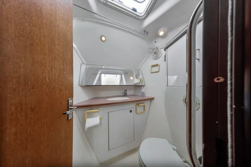 Romanc'n The Zea Yacht Photos Pics Bathroom interior of 1997 Hunter 456 yacht, featuring sink, mirror, and toilet.
