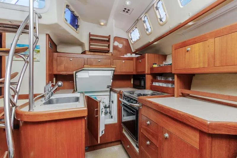 Romanc'n The Zea Yacht Photos Pics Interior of 1997 Hunter 456 sailboat kitchen with wooden cabinetry and modern appliances.