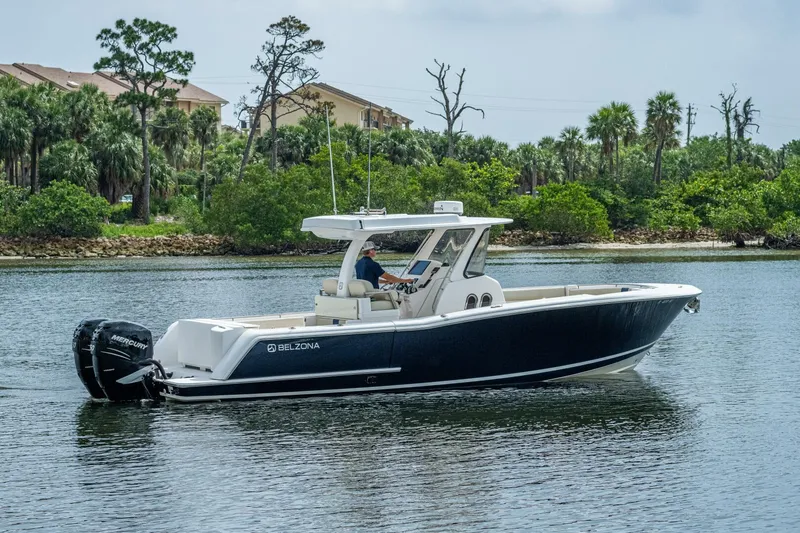  Yacht Photos Pics 2015 Belzona 32C boat cruising on a calm river with lush greenery in the background.