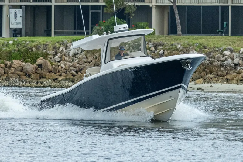  Yacht Photos Pics 2015 Belzona 32C boat cruising on water near rocky shoreline.