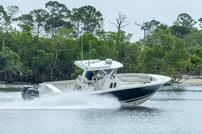  Yacht Photos Pics 2015 Belzona 32C boat cruising on a river near lush greenery.