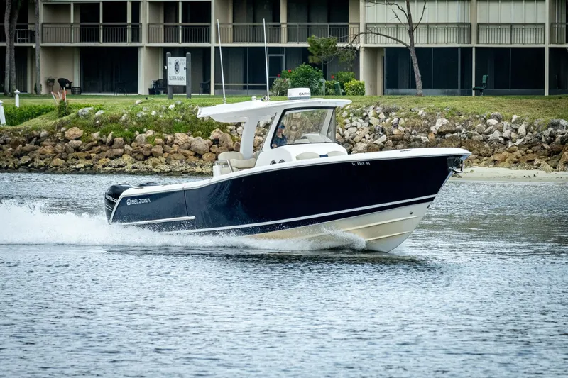  Yacht Photos Pics 2015 Belzona 32C boat cruising on water near rocky shoreline.