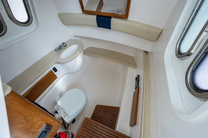  Yacht Photos Pics 2015 Belzona 32C boat interior bathroom with toilet, sink, and wooden accents.