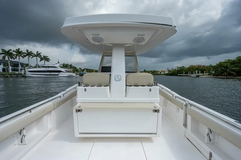  Yacht Photos Pics Belzona 32C 2015 boat interior with seating, on a cloudy day, docked near palm trees.