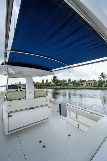  Yacht Photos Pics 2015 Belzona 32C boat with blue canopy on a calm waterway.