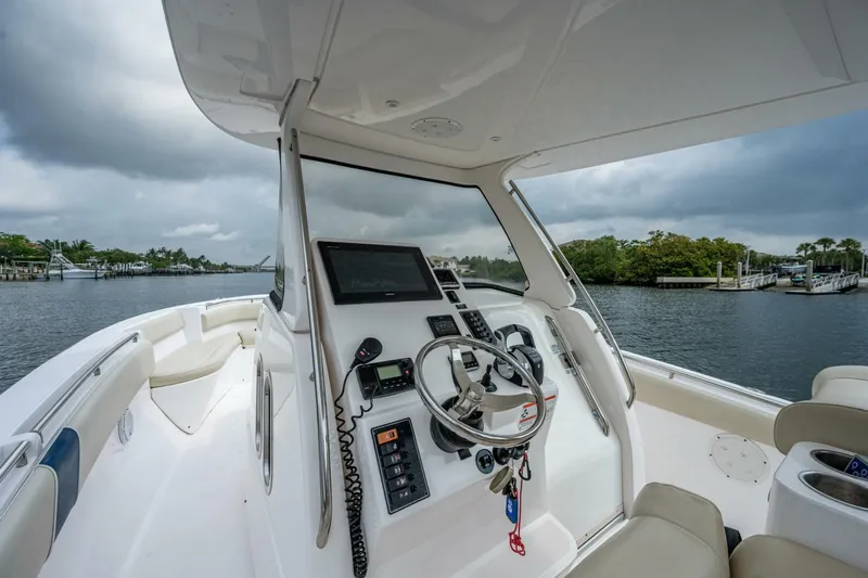  Yacht Photos Pics Belzona 32C 2015 boat helm with steering wheel and navigation equipment on a cloudy day.