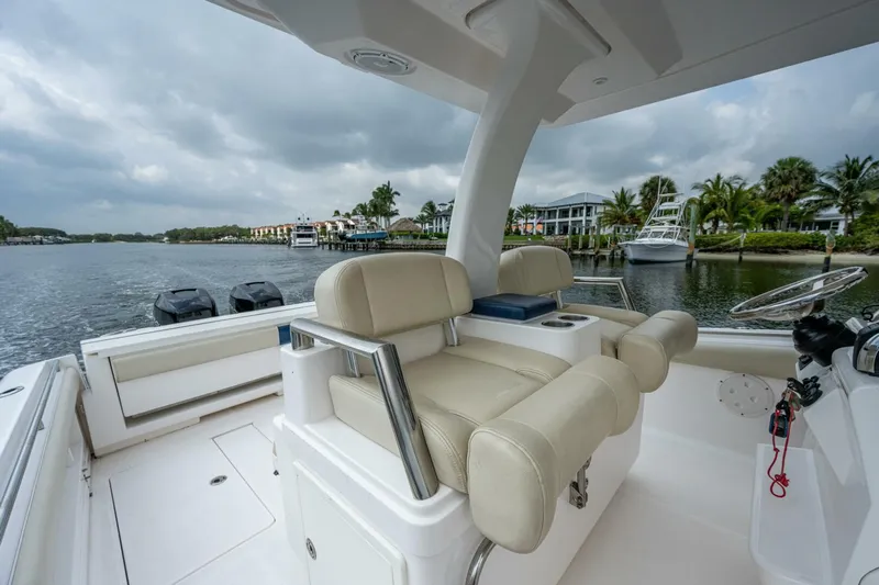  Yacht Photos Pics 2015 Belzona 32C boat interior with beige seating, steering wheel, and waterfront view.