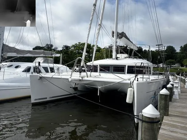 Sea Serenity Yacht Photos Pics 2012 Lagoon 560 catamaran docked at a marina under cloudy skies.
