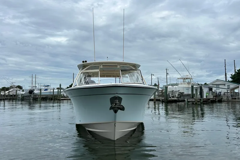  Yacht Photos Pics 2023 Grady-White Freedom 307 boat docked in a marina under cloudy skies.