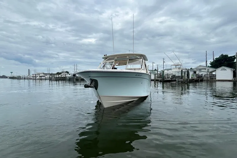  Yacht Photos Pics 2023 Grady-White Freedom 307 boat docked in a serene marina setting.
