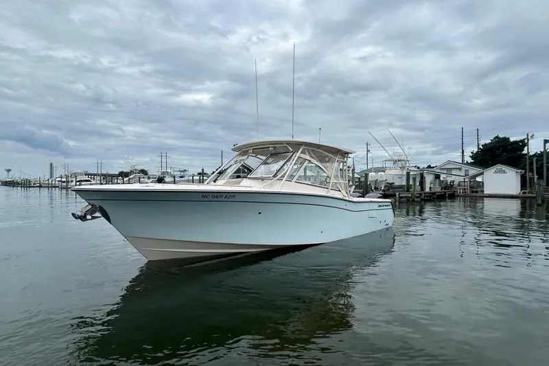  Yacht Photos Pics 2023 Grady-White Freedom 307 boat on calm water, overcast sky background.
