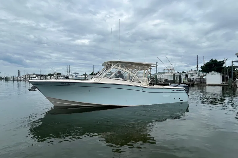  Yacht Photos Pics 2023 Grady-White Freedom 307 boat on calm water under cloudy sky.