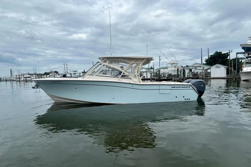  Yacht Photos Pics 2023 Grady-White Freedom 307 boat on calm water, overcast sky background.