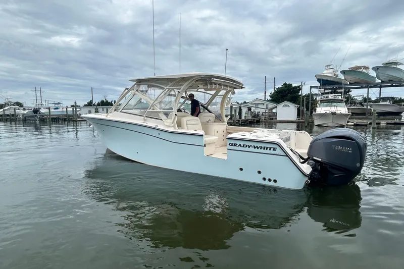  Yacht Photos Pics 2023 Grady-White Freedom 307 boat on calm water, featuring Yamaha outboard motor.