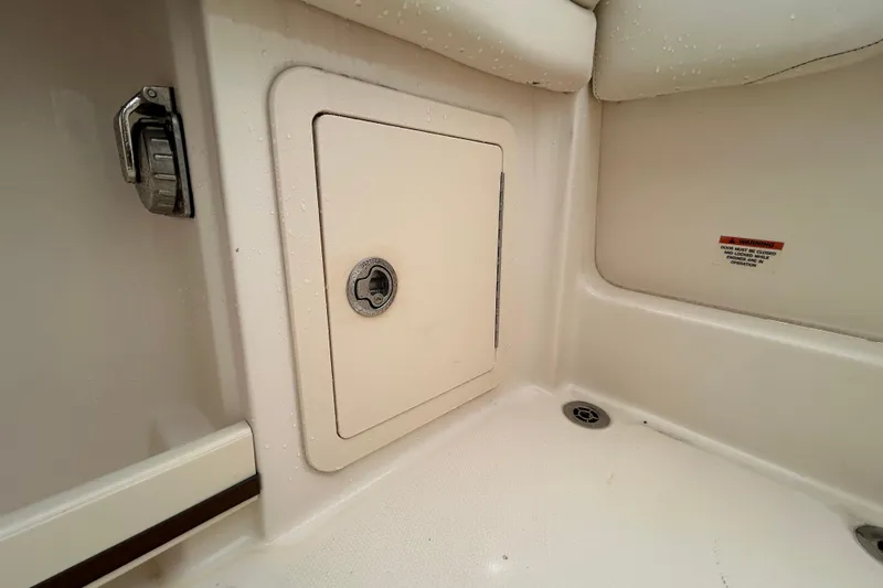  Yacht Photos Pics 2023 Grady-White Freedom 307 boat storage compartment with latch and warning label.