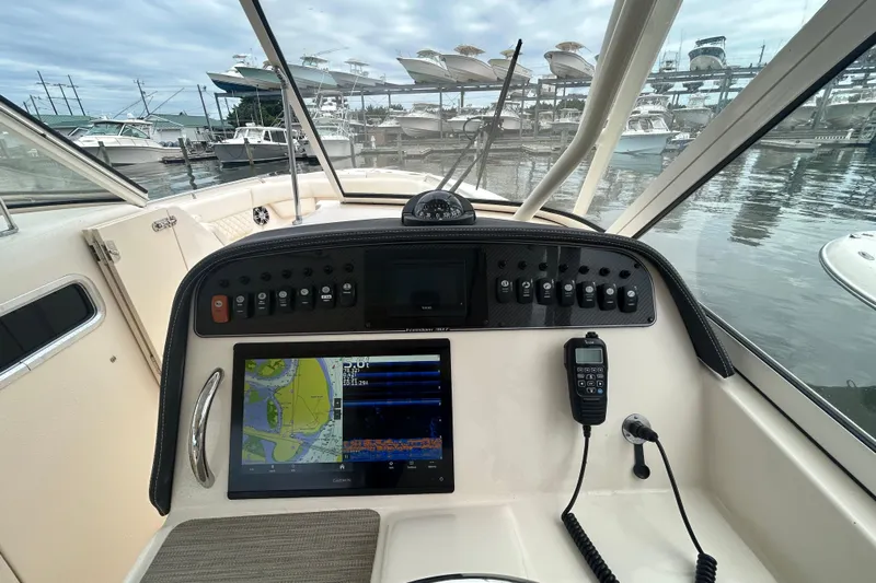  Yacht Photos Pics 2023 Grady-White Freedom 307 boat dashboard with navigation equipment and marina view.