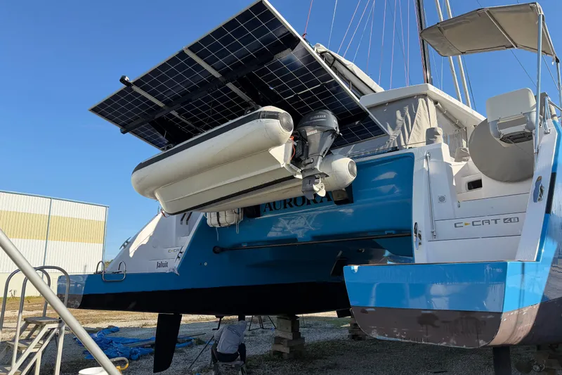 Aurora Yacht Photos Pics 2025 C-Catamarans 48 with solar panels and dinghy, docked under clear blue sky.