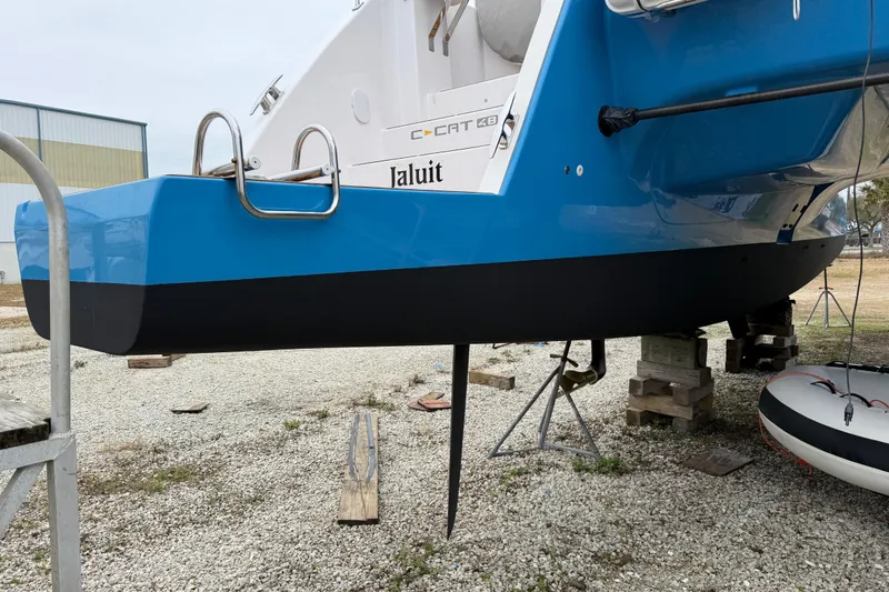 Aurora Yacht Photos Pics 2025 C-Catamarans 48 in dry dock, blue hull, ladder, and rudder visible.