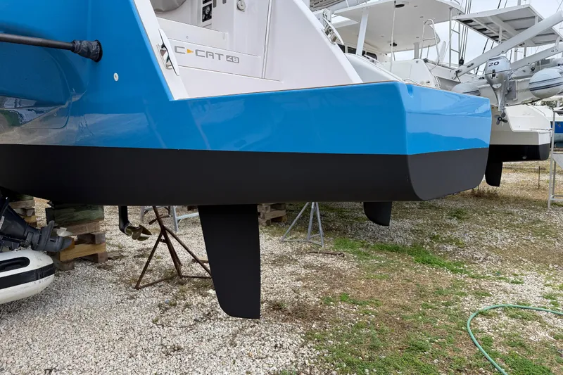 Aurora Yacht Photos Pics 2025 C-Catamarans 48 with blue and black hull, displayed on gravel.