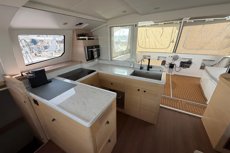 Aurora Yacht Photos Pics Modern kitchen interior of 2025 C-Catamarans 48, featuring sleek countertops and wooden flooring.