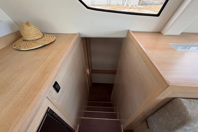 Aurora Yacht Photos Pics Interior of 2025 C-Catamarans 48, featuring wooden stairs and a straw hat on a shelf.