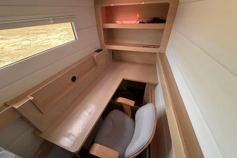 Aurora Yacht Photos Pics Modern interior workspace on 2025 C-Catamarans 48, featuring wooden desk and shelves.
