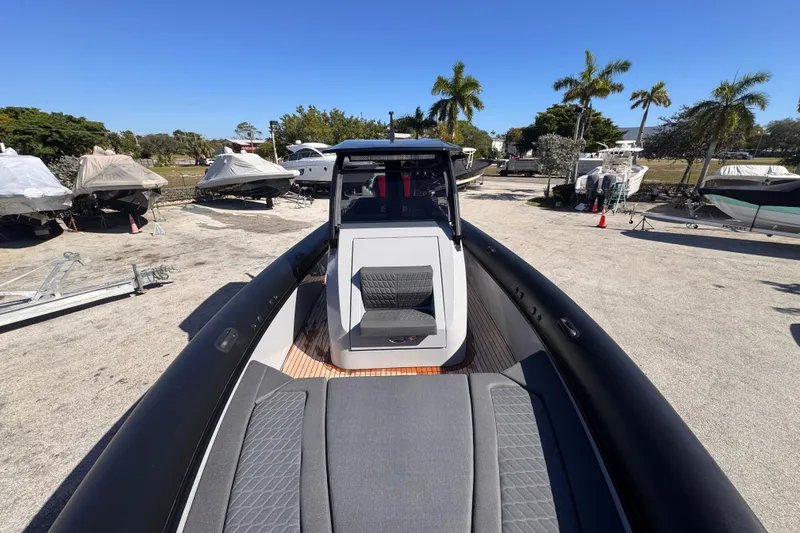 Yacht Photos Pics 2025 Skipper-BSK 38NC boat on display, surrounded by other covered boats and palm trees.