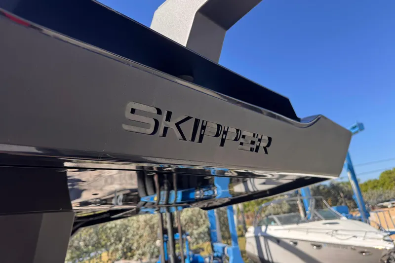  Yacht Photos Pics 2025 Skipper-BSK 38NC boat detail with logo, against a clear blue sky.