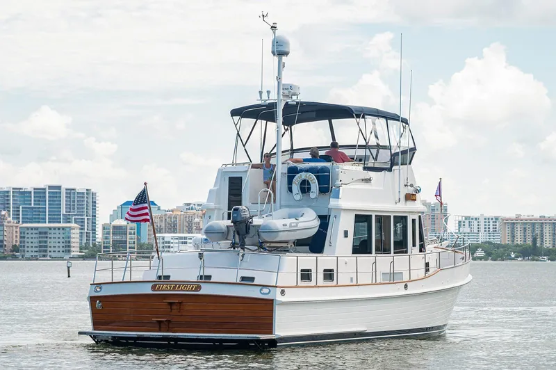 First Light Yacht Photos Pics 2007 Grand Banks 47 Classic yacht on water with city skyline in background.