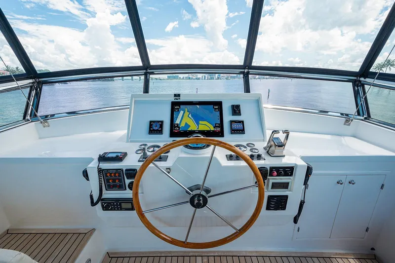 First Light Yacht Photos Pics Helm of 2007 Grand Banks 47 Classic yacht with navigation equipment and wooden steering wheel.