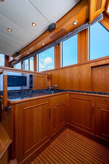 First Light Yacht Photos Pics Luxurious 2007 Grand Banks 47 Classic yacht kitchen with wood cabinetry and modern appliances.