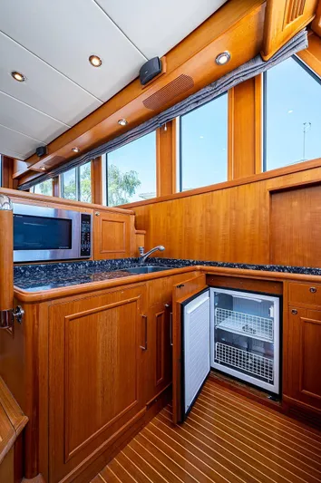 First Light Yacht Photos Pics 2007 Grand Banks 47 Classic yacht kitchen with wood cabinetry and modern appliances.
