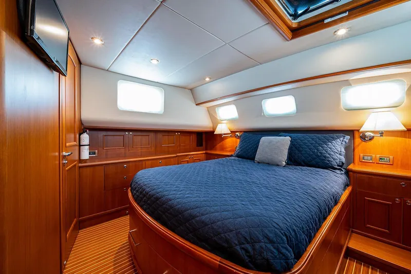 First Light Yacht Photos Pics Luxurious cabin interior of 2007 Grand Banks 47 Classic yacht with wood finish and cozy bedding.
