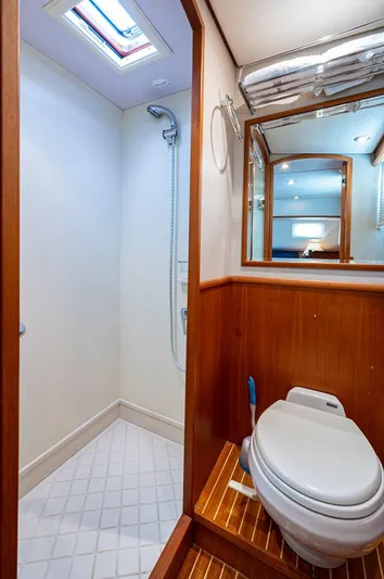 First Light Yacht Photos Pics 2007 Grand Banks 47 Classic yacht bathroom with shower, wooden accents, and modern fixtures.